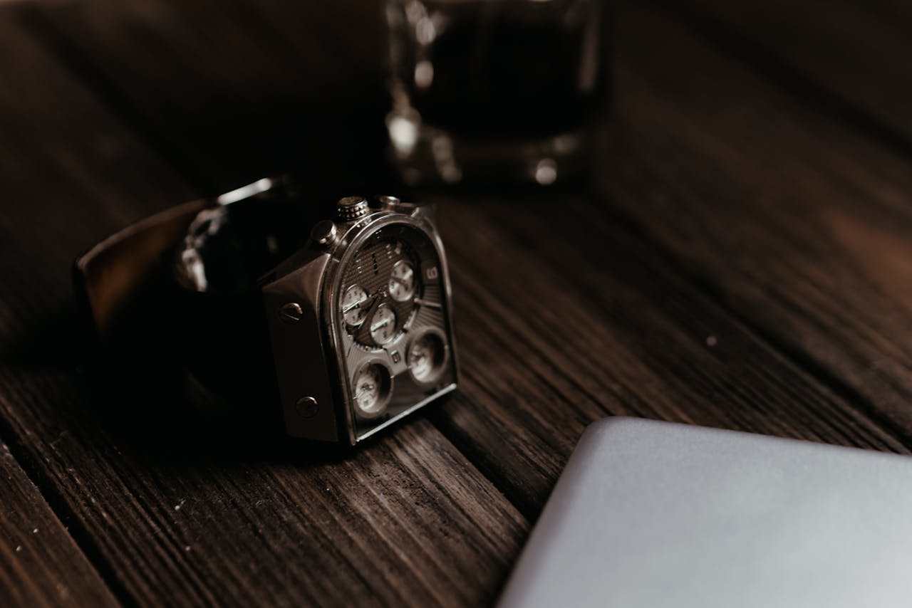 Modern analog wristwatch on a wooden tabletop with blurred background, showcasing luxury and elegance.