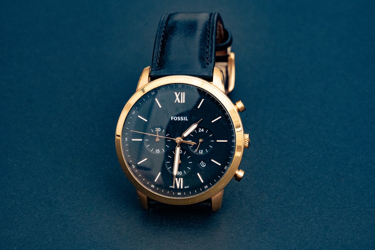 Luxury Fossil wristwatch with a black leather strap and gold casing, showcasing elegance and precision.